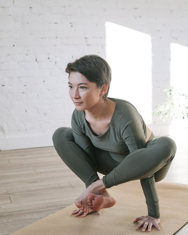 Woman in a calm yoga pose in a bright, peaceful room.